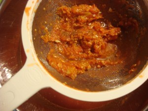 I strain the sauce through a regular strainer, then eat the seeds and solids!